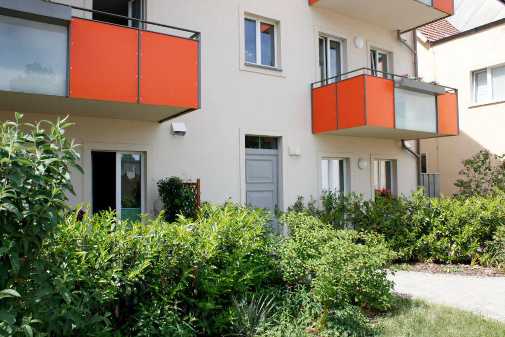 Innenhof kleine Kettenstraße 5, orangene Balkone, grüne Bepflanzung, WBG Wittstock
