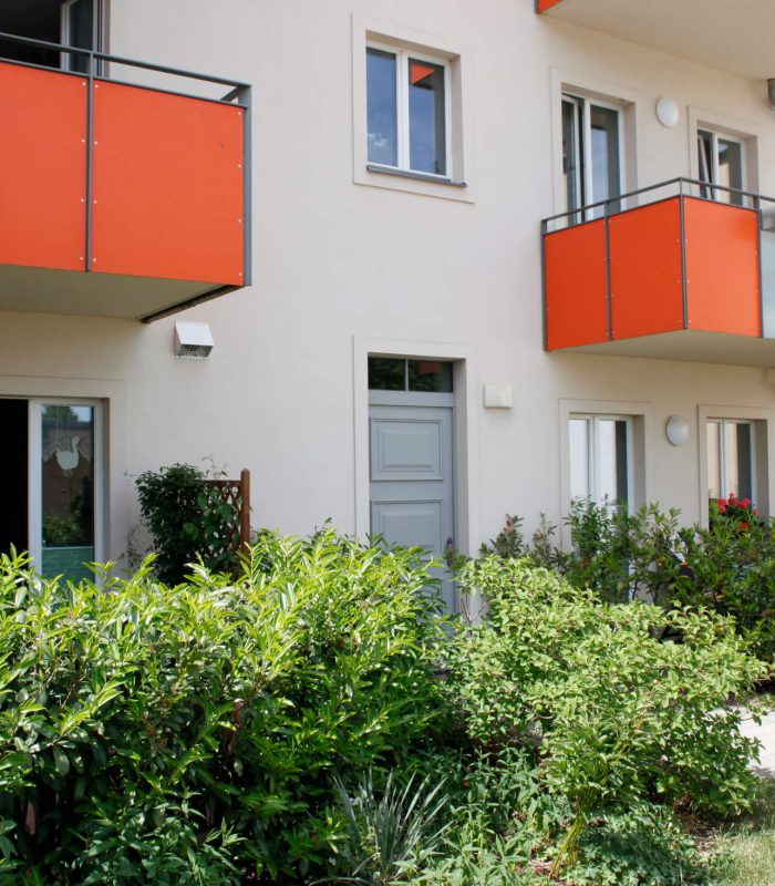 Innenhof kleine Kettenstraße 5, orangene Balkone, grüne Bepflanzung, WBG Wittstock